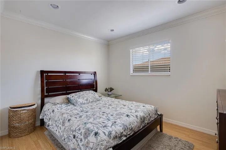 Bedroom with ornamental molding and light wood-style floors