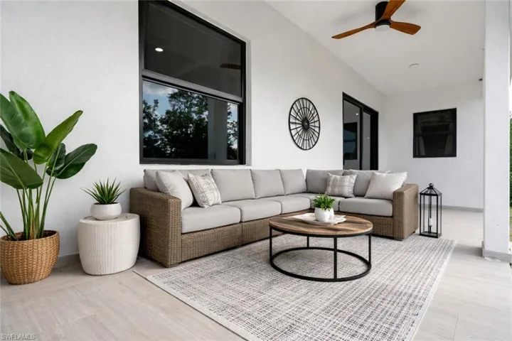 Living area with a ceiling fan and baseboards