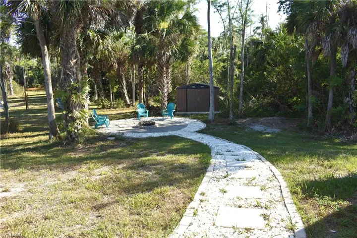 View of yard with an outdoor fire pit and a storage unit