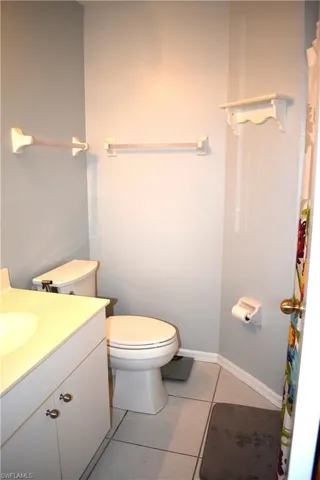 Bathroom with tile flooring, vanity, and toilet