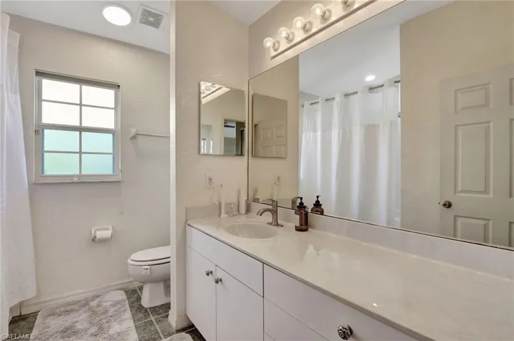 Bathroom with vanity, light tile patterned floors, and curtained shower