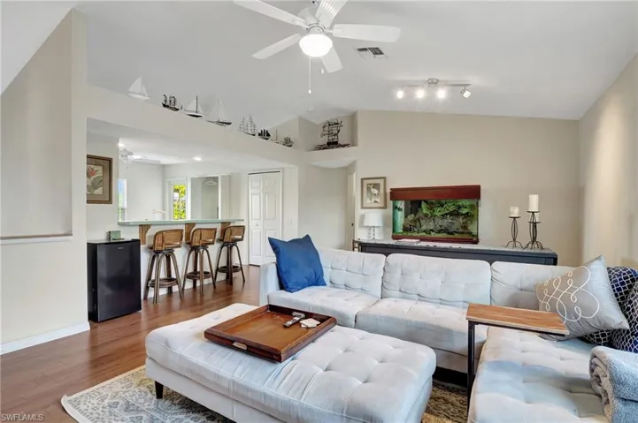 Living area with wood finished floors, a ceiling fan, and high vaulted ceiling