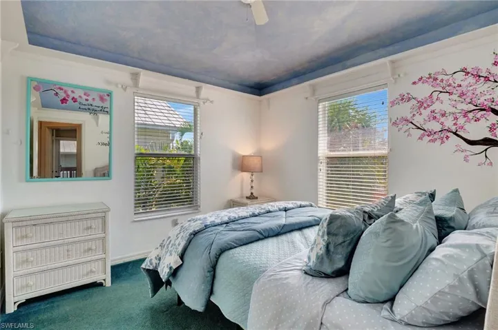 Bedroom featuring multiple windows, carpet, and ceiling fan