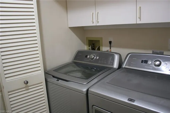 Washroom featuring cabinet space and washer and dryer