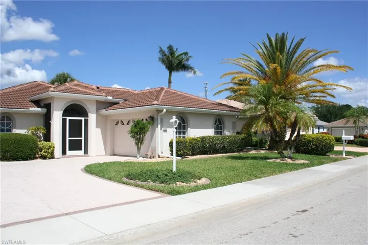 View of front of house with an attached garage, stucco siding, a tiled roof, and driveway