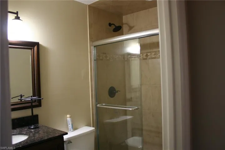 Full bathroom with vanity, a stall shower, and toilet