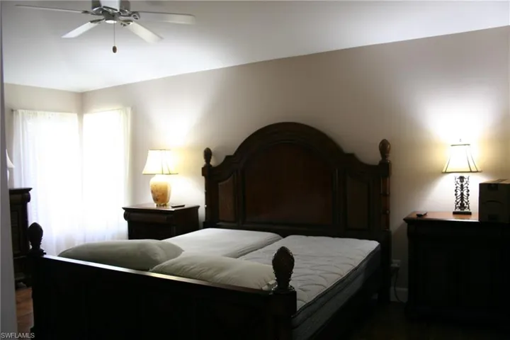 Bedroom featuring ceiling fan and dark wood-type flooring