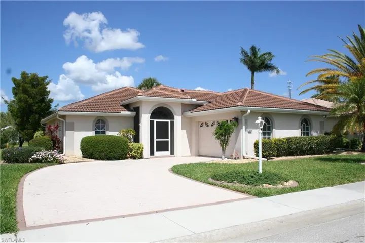 Mediterranean / spanish-style home featuring an attached garage, a tile roof, a front yard, and stucco siding