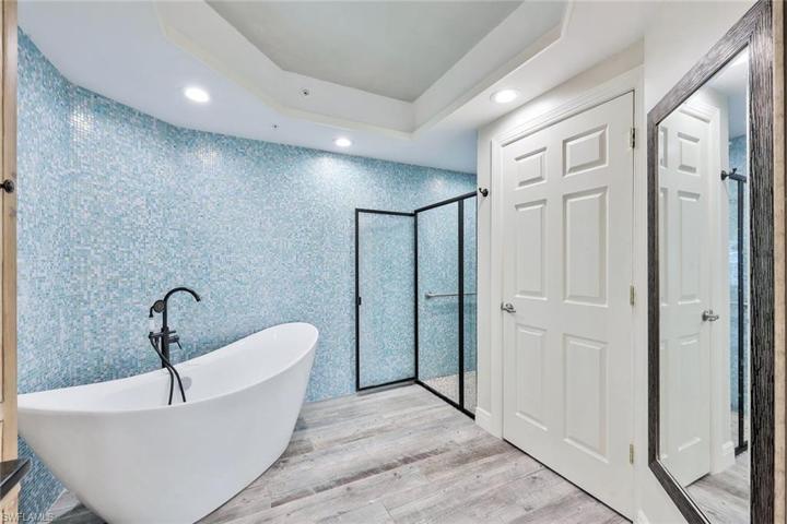 Free standing tub with beautiful mosaic tile wall and walk-in shower