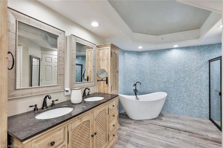 Primary bathroom with double sinks, separate vanity storage, freestanding tub and walk-in shower!