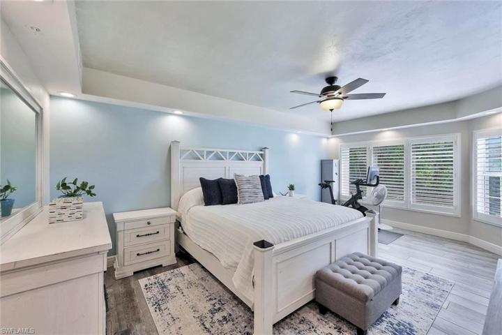 Primary bedroom with direct access to your lanai, plantation shutters and en suite bathroom