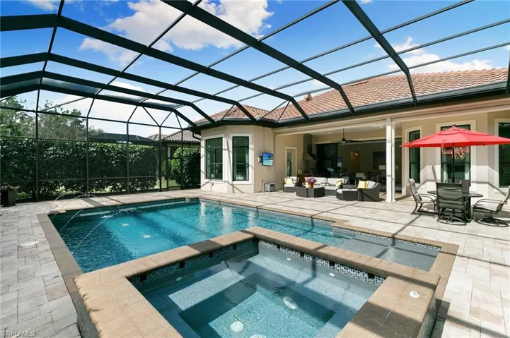 Integrated pool / hot tub with a sunroom, glass enclosure, a patio area, and outdoor lounge area