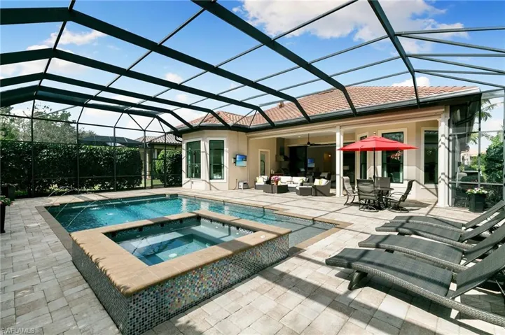 Relaxing pool / spa with a sunroom and a lanai