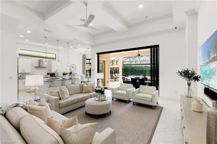 Living room featuring coffered ceiling, a sunroom, a ceiling fan, ornamental molding, and recessed lighting
