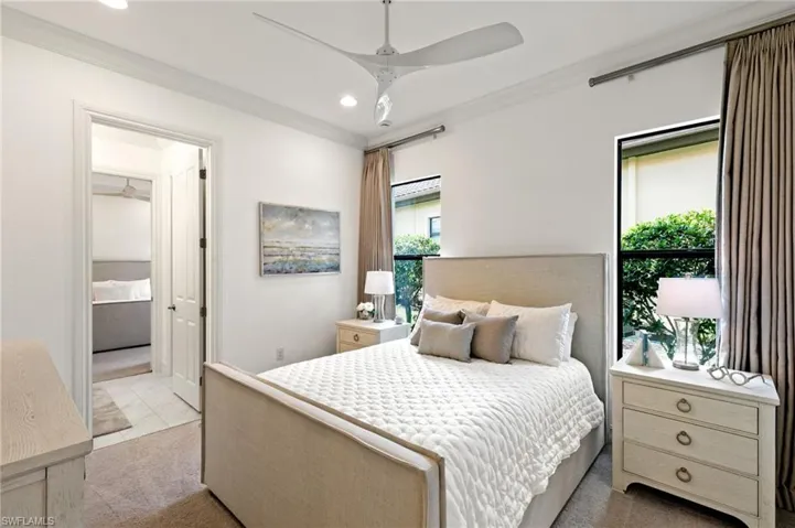 Bedroom with ornamental molding, recessed lighting, light colored carpet, and ensuite bathroom