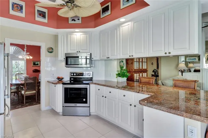 Open Kitchen featuring backsplash, appliances with stainless steel finishes, rich stone counters, and white cabinets