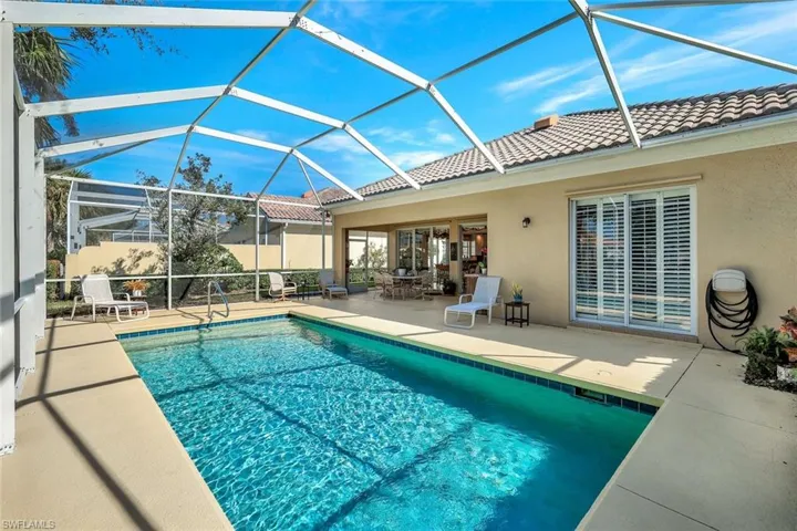 View of swimming pool featuring a patio and glass enclosure