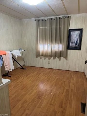 Unfurnished room featuring hardwood / wood-style flooring and a textured ceiling