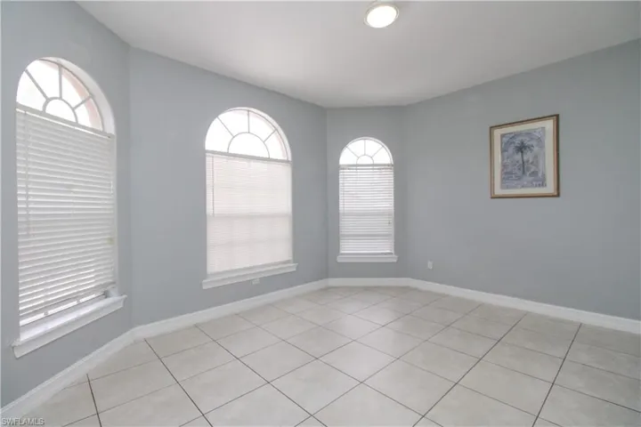 Empty room with light tile patterned floors and baseboards