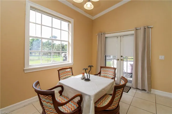 Dining room featuring french doors, ornamental molding, light tile patterned flooring, and baseboards
