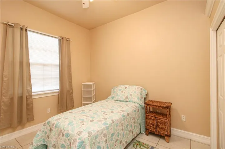 Bedroom with baseboards, a ceiling fan, and light tile patterned flooring