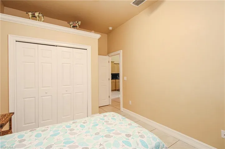 Bedroom featuring baseboards, visible vents, a closet, and light tile patterned flooring