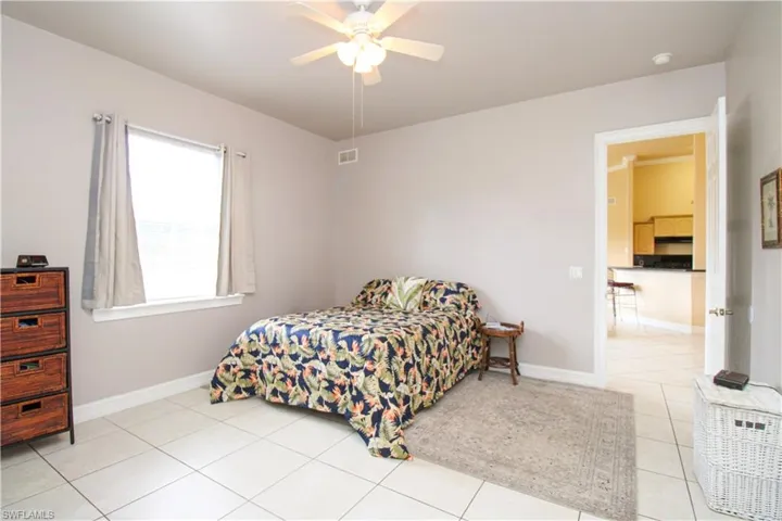 Bedroom featuring a ceiling fan, visible vents, baseboards, and light tile patterned floors