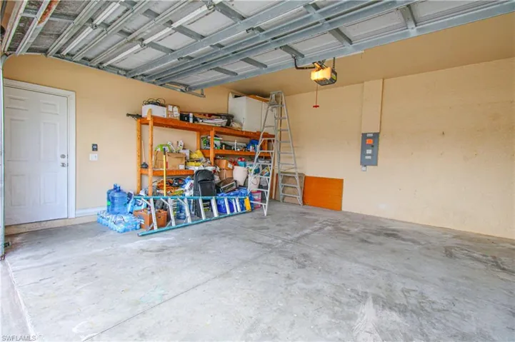 Garage featuring a garage door opener and electric panel