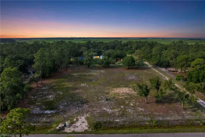 Expansive undeveloped lot featuring a natural landscape and surrounding mature trees