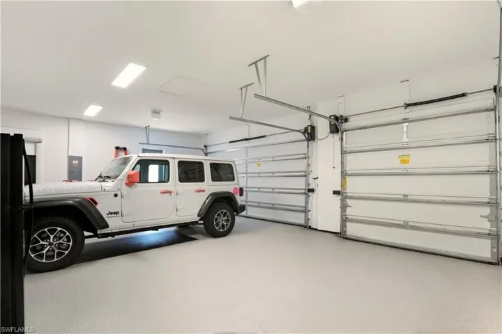 Garage featuring freestanding refrigerator and electric panel