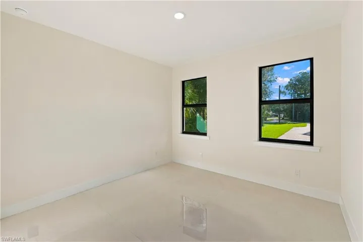 Light-toned walls, recessed lighting, and rectangular windows with dark frames