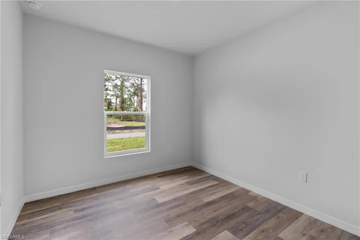Spare room featuring light wood finished floors and baseboards
