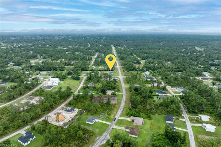 View of property location with a forest and nearby suburban area