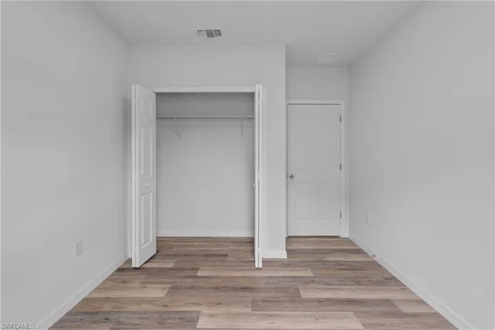 Unfurnished bedroom featuring light wood finished floors and a closet