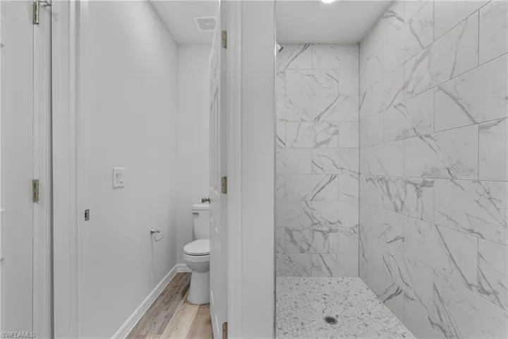 Full bathroom with a stall shower and light wood-type flooring