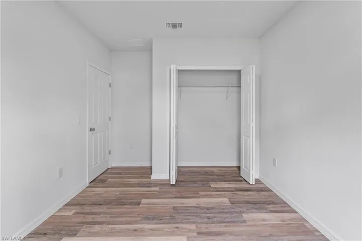 Unfurnished bedroom featuring light wood-type flooring and a closet