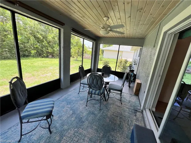 Sunroom / solarium featuring ceiling fan and wooden ceiling