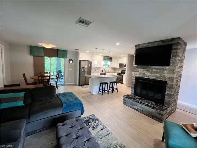 Living room featuring a stone fireplace and light hardwood / wood-style floors