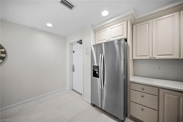 Kitchen featuring stainless steel refrigerator with ice dispenser, light countertops, recessed lighting, and light tile patterned flooring
