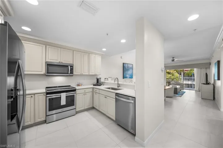 Kitchen featuring stainless steel appliances, a ceiling fan, light tile patterned floors, open floor plan, and recessed lighting