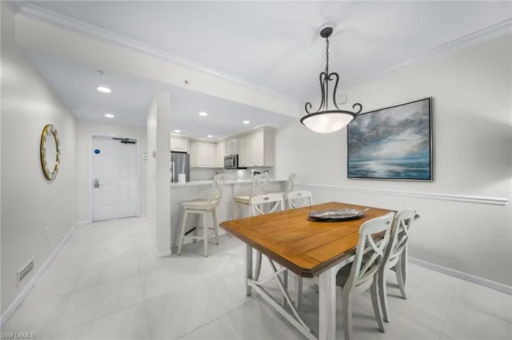 Dining room with ornamental molding, recessed lighting, and light tile patterned floors