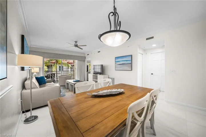 Tiled dining area featuring crown molding and a ceiling fan