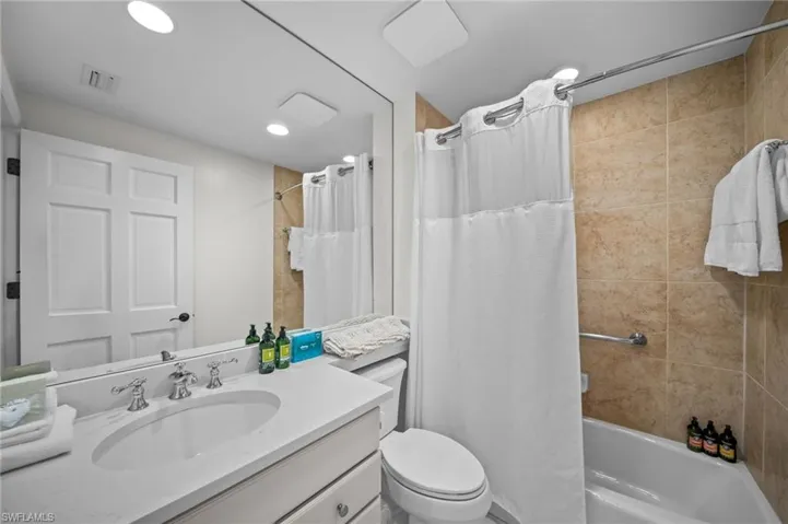 Full bath with vanity, shower / bathtub combination with curtain, and recessed lighting