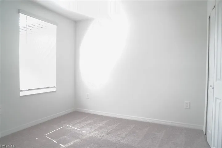 Empty room featuring baseboards and carpet