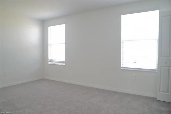 Empty room with carpet flooring and baseboards