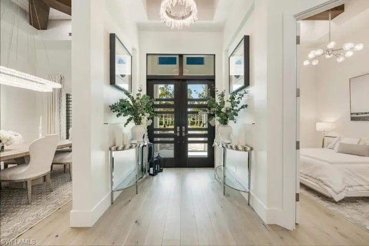 Entryway with a chandelier, wood finished floors, french doors, baseboards, and a high ceiling
