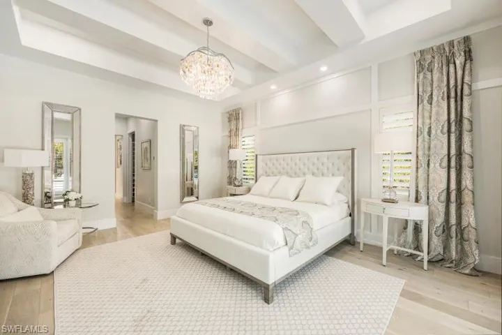 Master Bedroom with a chandelier, multiple windows, light wood finished floors, recessed lighting, and beamed ceiling