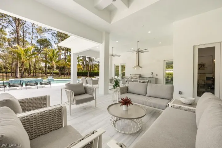Living room with ceiling fan, a towering ceiling, and recessed lighting