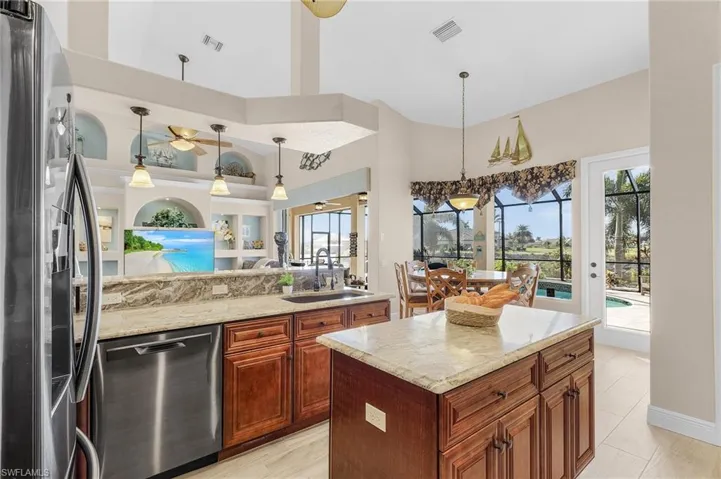 Kitchen featuring plenty of natural light, a towering ceiling, sink, and appliances with stainless steel finishes