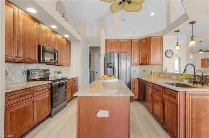 Kitchen featuring tasteful backsplash, pendant lighting, appliances with stainless steel finishes, and sink